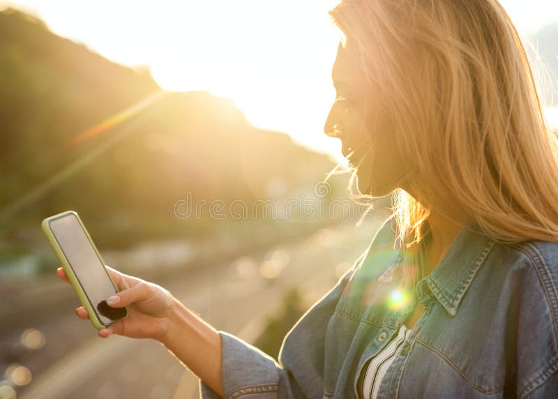 Le free lance della ragazza al tramonto parlano sul telefono e lavorano fotografia stock libera da diritti Le free lance della ragazza al tramonto parlano sul telefono e lavorano fotografia stock libera da diritti