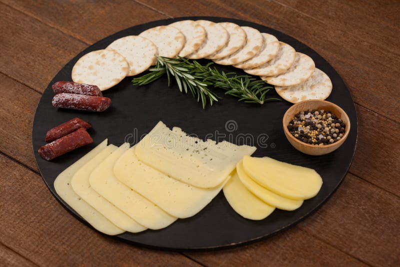 Le fromage, le romarin, les saucisses, les épices, les biscuits et les pommes de terre sur l'ardoise embarquent images libres de droits Le fromage, le romarin, les saucisses, les épices, les biscuits et les pommes de terre sur l'ardoise embarquent images libres de droits