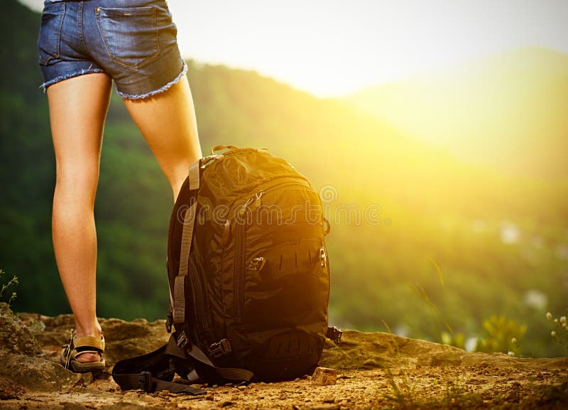 Le gambe di un turista e di un viaggio della donna backpack su una cima della montagna