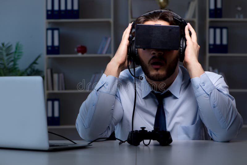Le gamer d'homme d'affaires restant tard pour jouer des jeux photographie stock Le gamer d'homme d'affaires restant tard pour jouer des jeux photographie stock