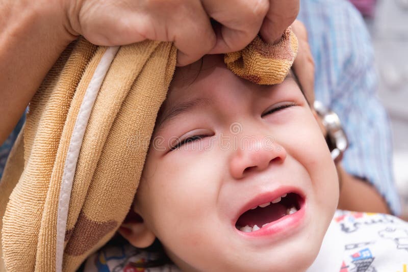 garçon pleure de douleur. l'enfant se cogne la tête contre le