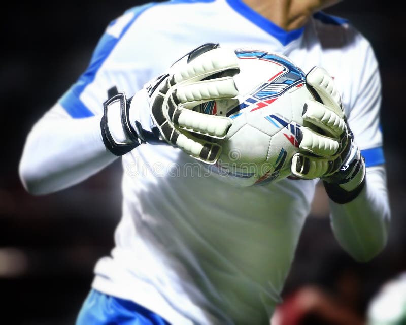 Le gardien de but attrape le ballon de football photographie stock libre de droits Le gardien de but attrape le ballon de football photographie stock libre de droits