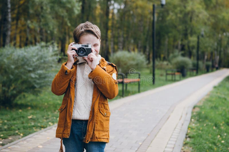 Le garçon mignon marche et pose en parc coloré d'automne photographie stock libre de droits Le garçon mignon marche et pose en parc coloré d'automne photographie stock libre de droits