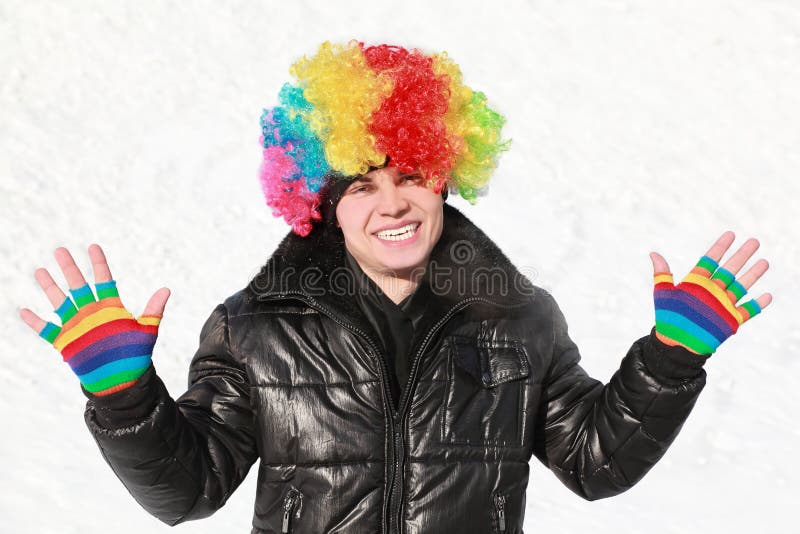 Le garçon reste dans la perruque du clown et affiche les gants lumineux photos libres de droits Le garçon reste dans la perruque du clown et affiche les gants lumineux photos libres de droits
