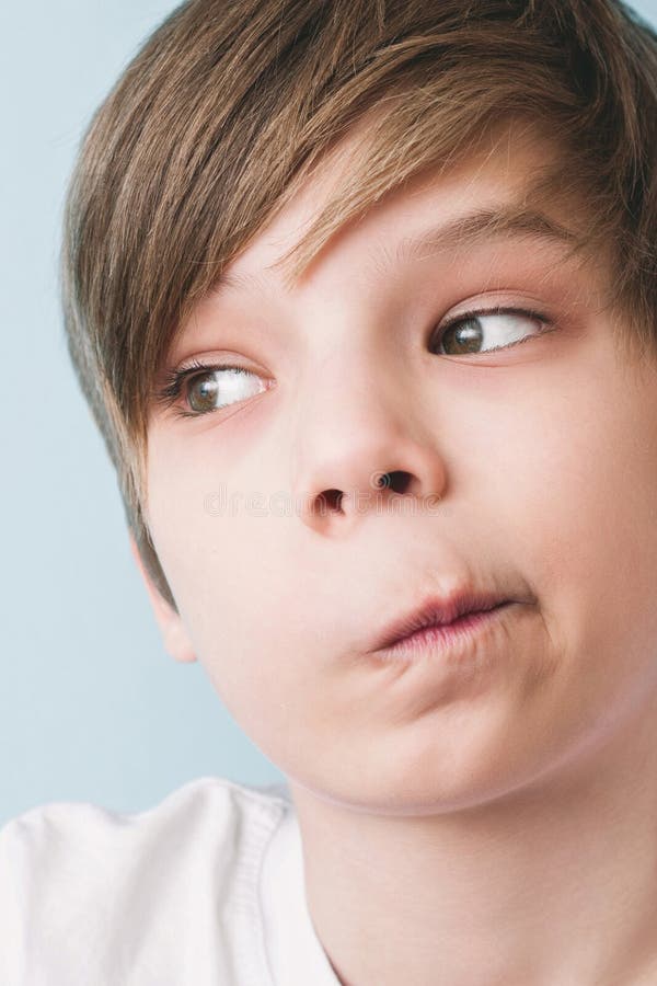 Le garçon étonné a tordu sa bouche dans la grimace de la perplexité photographie stock Le garçon étonné a tordu sa bouche dans la grimace de la perplexité photographie stock