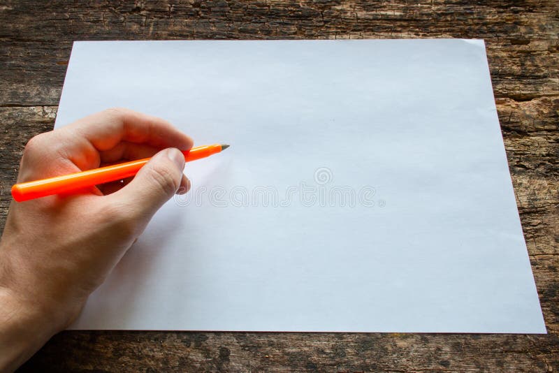Le gauchiste écrit avec un stylo bille sur une feuille de papier sur la table en bois photographie stock libre de droits Le gauchiste écrit avec un stylo bille sur une feuille de papier sur la table en bois photographie stock libre de droits