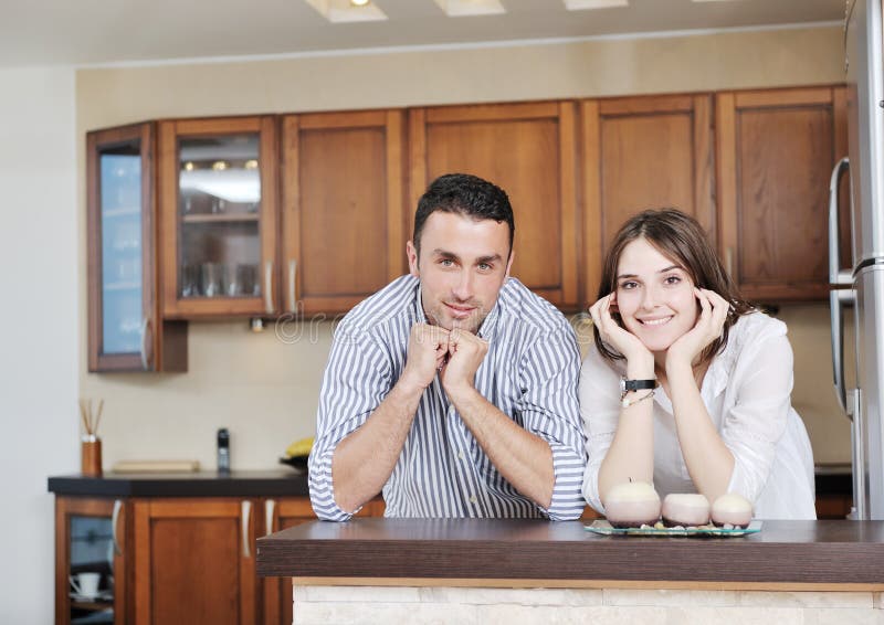 Le giovani coppie felici hanno divertimento in cucina moderna immagini stock libere da diritti Le giovani coppie felici hanno divertimento in cucina moderna immagini stock libere da diritti