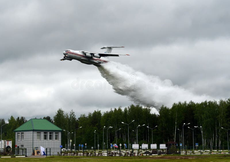 Le gocce degli aerei IL-76TD della lotta contro l'incendio innaffiano sopra la gamma del centro EMERCOM di salvataggio di Noginsk immagine stock Le gocce degli aerei IL-76TD della lotta contro l'incendio innaffiano sopra la gamma del centro EMERCOM di salvataggio di Noginsk immagine stock