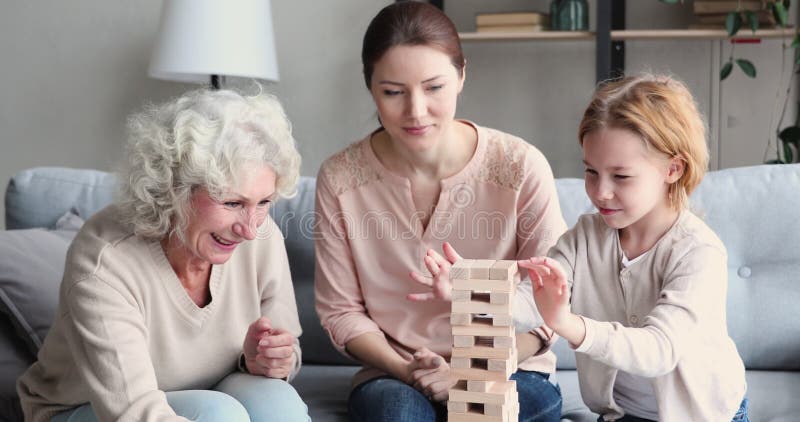 Le gran heureuse et maman soutenant peu d'enfant dans le jeu de construction. banque de vidéos