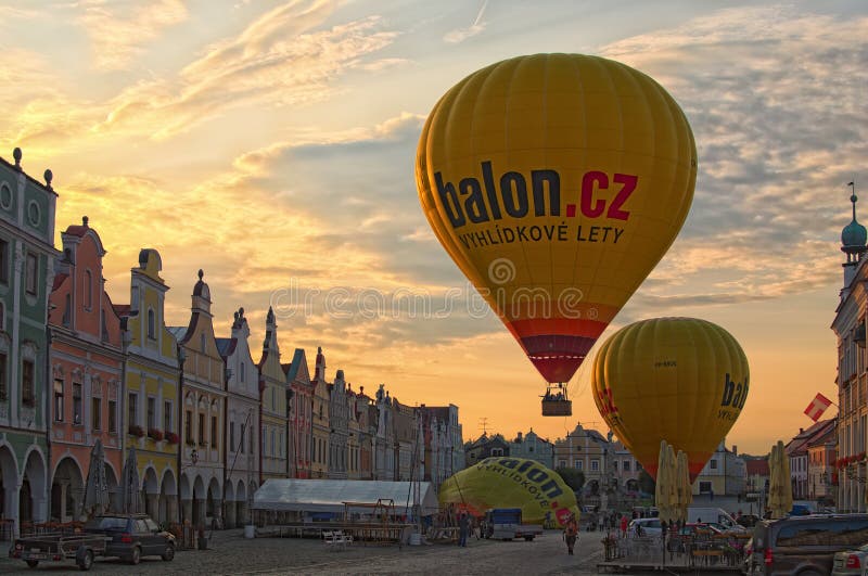 Le grand ballon à air chaud jaune décollent de la place principale de la ville Telc Deux autres ballons à air chauds préparent po images libres de droits Le grand ballon à air chaud jaune décollent de la place principale de la ville Telc Deux autres ballons à air chauds préparent po images libres de droits