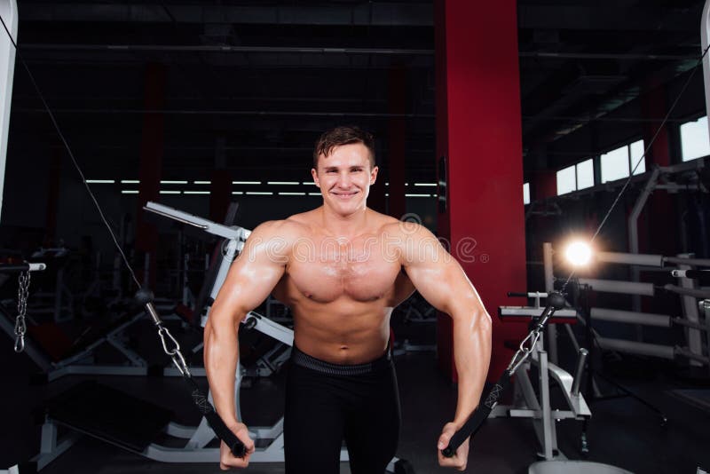 Le grand bodybuider fort sans chemises démontrent des exercices de croisement Les muscles pectoraux et la formation dure photographie stock Le grand bodybuider fort sans chemises démontrent des exercices de croisement Les muscles pectoraux et la formation dure photographie stock