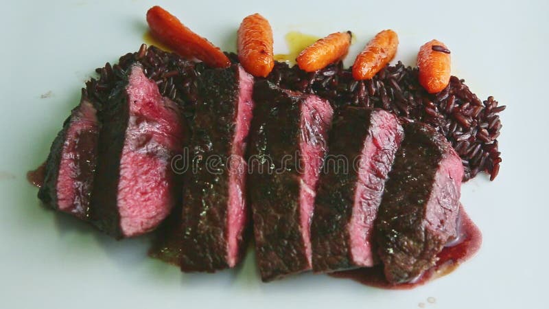 Le gros plan de vue de dessus a grillé tout entier de la viande découpée en tranches avec du riz, la carotte, et la sauce banque de vidéos