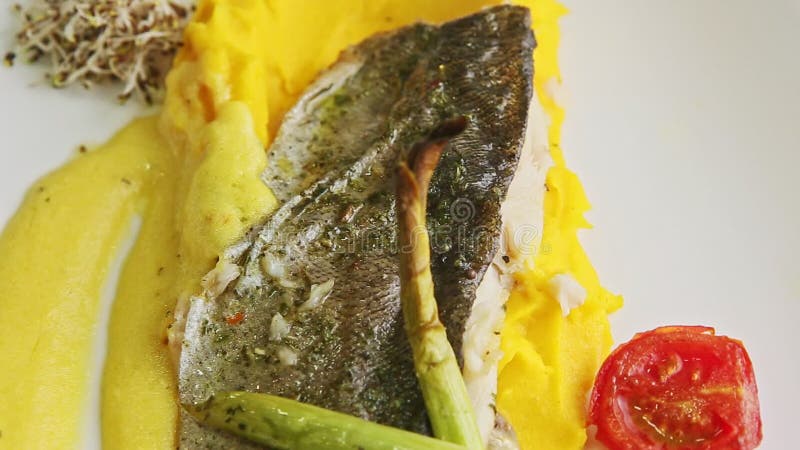 Le gros plan de vue supérieure est frit le filet de poisson sur le purre de pommes de terre et de légumes taillé en tranches tour clips vidéos