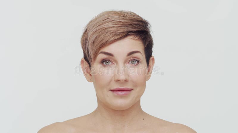 Le gros plan du milieu de la femme mûre au-dessus du bacjground blanc. Portrait de femme mûre. Les injections de beauté de chirurg clips vidéos