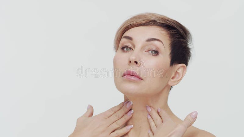 Le gros plan du milieu de la femme mûre au-dessus du bacjground blanc. Portrait de femme mûre. Les injections de beauté de chirurg clips vidéos