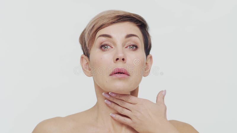 Le gros plan du milieu de la femme mûre au-dessus du bacjground blanc. Portrait de femme mûre. Les injections de beauté de chirurg clips vidéos