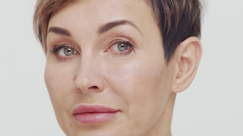 Le gros plan du milieu de la femme mûre au-dessus du bacjground blanc. Portrait de femme mûre. Les injections de beauté de chirurg clips vidéos