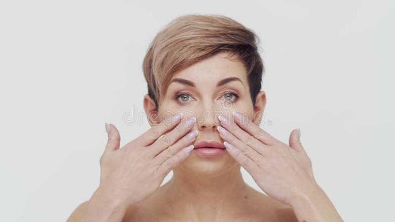 Le gros plan du milieu de la femme mûre au-dessus du bacjground blanc. Portrait de femme mûre. Les injections de beauté de chirurg clips vidéos