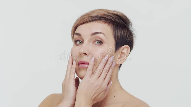 Le gros plan du milieu de la femme mûre au-dessus du bacjground blanc. Portrait de femme mûre. Les injections de beauté de chirurg clips vidéos