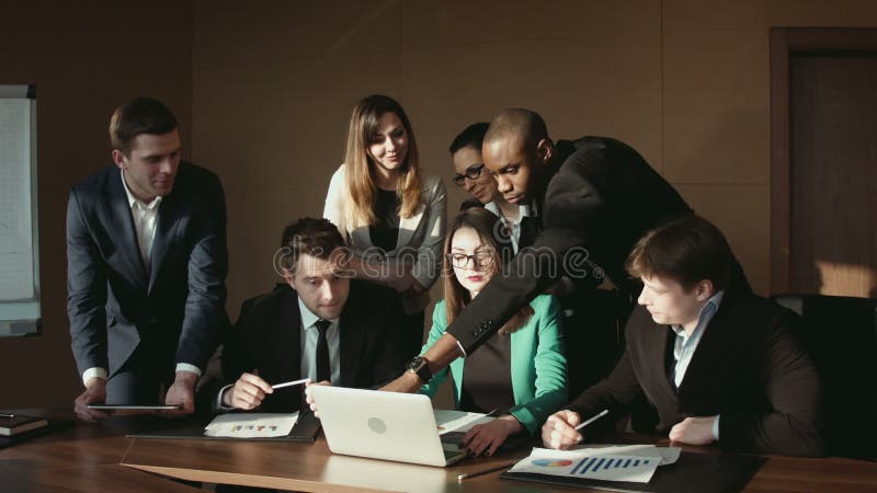 Le groupe de l'homme d'affaires communiquent à l'aide de l'ordinateur portable