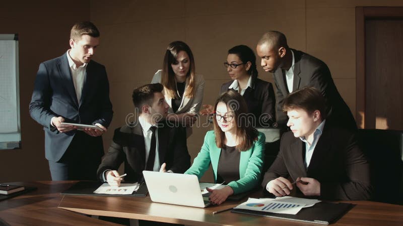 Le groupe de l'homme d'affaires communiquent à l'aide de l'ordinateur portable