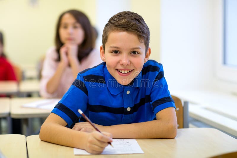 Le groupe de l'école badine l'essai d'écriture dans la salle de classe photos stock Le groupe de l'école badine l'essai d'écriture dans la salle de classe photos stock