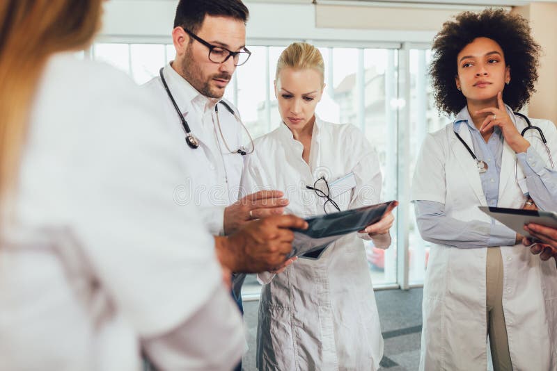 Le groupe de m? decins discutent le balayage de rayon X photo libre de droits
