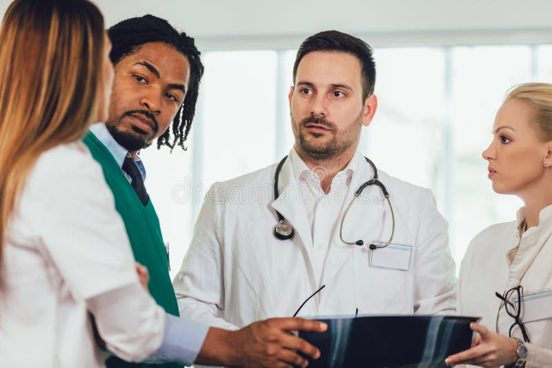 Le groupe de m? decins discutent le balayage de rayon X photographie stock libre de droits