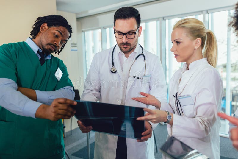 Un groupe de médecins discute d'une radiographie photo libre de droits