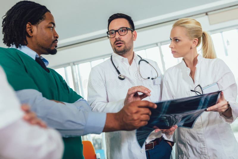 Le groupe de médecins discutent le balayage de rayon X photo libre de droits