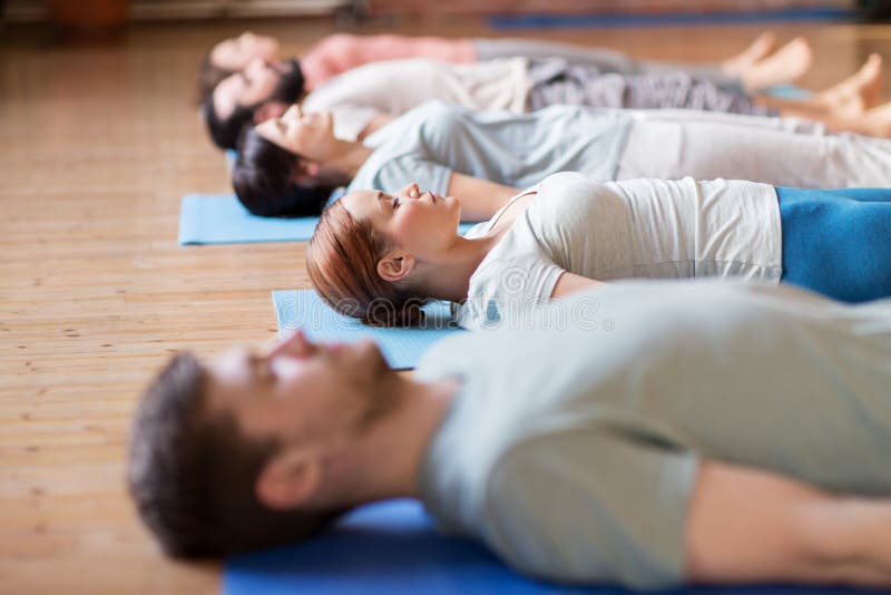 Le groupe de personnes faisant le yoga s'exerce au studio photographie stock libre de droits