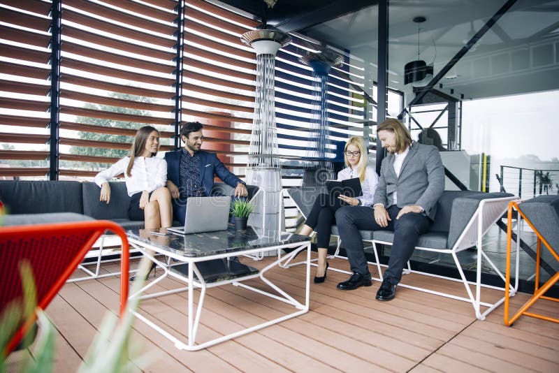 Le groupe des jeunes dans le bureau moderne ont la réunion et les cerveaux d'équipe photographie stock libre de droits Le groupe des jeunes dans le bureau moderne ont la réunion et les cerveaux d'équipe photographie stock libre de droits