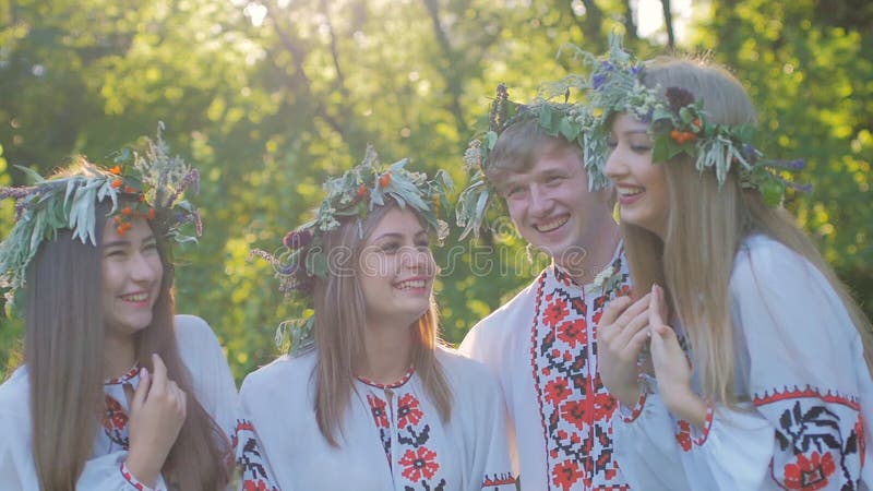 Le groupe des jeunes dans des costumes nationaux slaves célèbrent le solstice d'été Un groupe de filles et de garçons parlant et clips vidéos