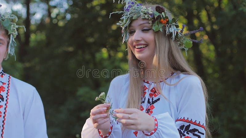 Le groupe des jeunes dans des costumes nationaux slaves célèbrent le solstice d'été Un groupe de filles et de garçons parlant et banque de vidéos