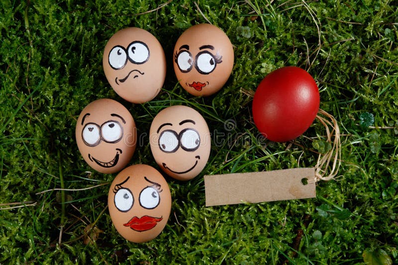 Le groupe du visage heureux eggs sur l'herbe verte image stock Le groupe du visage heureux eggs sur l'herbe verte image stock
