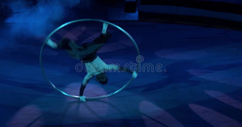 Le gymnaste exécute sur la scène du cirque tournant dans le cercle 4k banque de vidéos