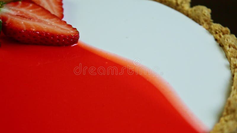 Le gâteau au fromage vitré en gros plan avec la décoration en tranches tourne autour de fraises clips vidéos
