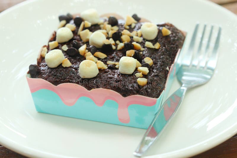 Le gâteau de chocolat de 'brownie' ont la guimauve, l'amande, puce de chocolat sur l'écrimage sur le plat blanc images libres de droits Le gâteau de chocolat de 'brownie' ont la guimauve, l'amande, puce de chocolat sur l'écrimage sur le plat blanc images libres de droits