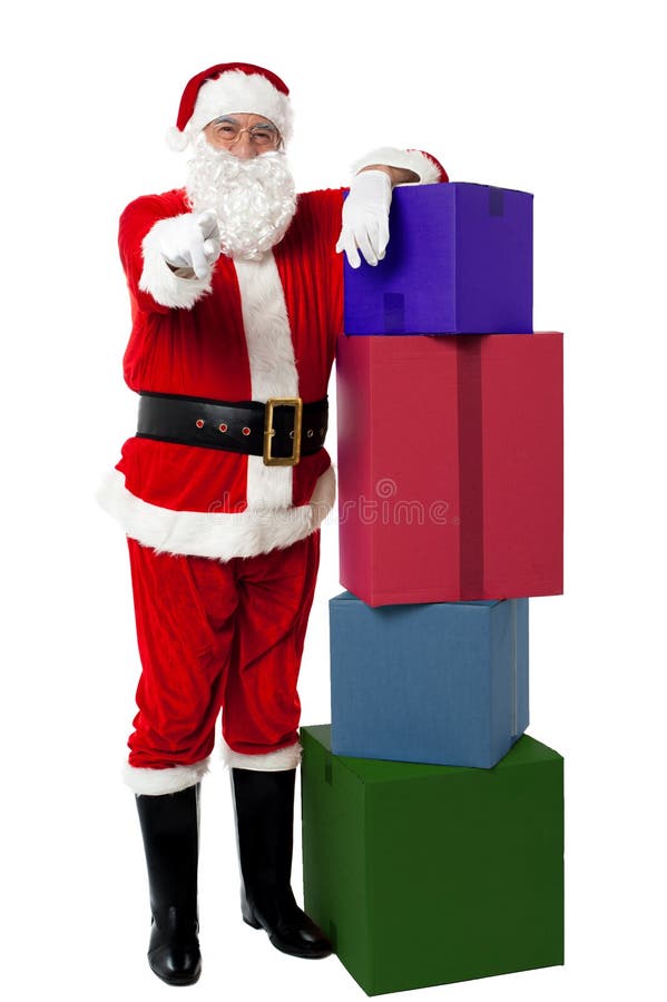Le höga Santa som poserar bredvid färgrik bunt royaltyfri fotografi Le höga Santa som poserar bredvid färgrik bunt royaltyfri fotografi