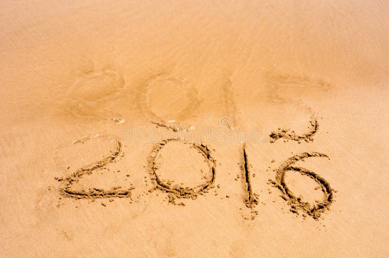 Le iscrizioni 2015 e 2016 su una sabbia della spiaggia, l'onda stanno cominciando riguardare le cifre 2015 immagini stock libere da diritti Le iscrizioni 2015 e 2016 su una sabbia della spiaggia, l'onda stanno cominciando riguardare le cifre 2015 immagini stock libere da diritti