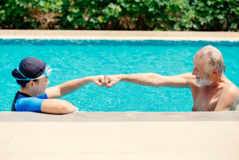 Le jeu heureux d'ancien sain de couples ensemble à la piscine apprécient la vie de vacances d'été amusant après covid19