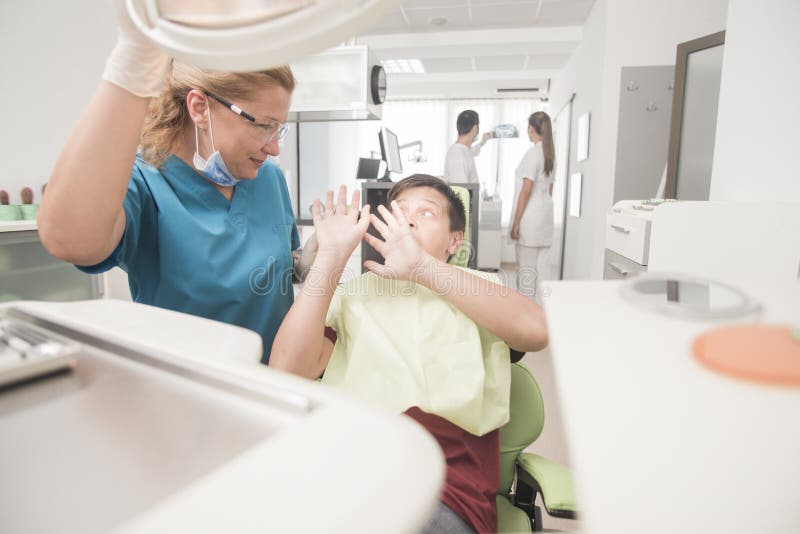 Le jeune adolescent est terrifié du dentiste images libres de droits Le jeune adolescent est terrifié du dentiste images libres de droits