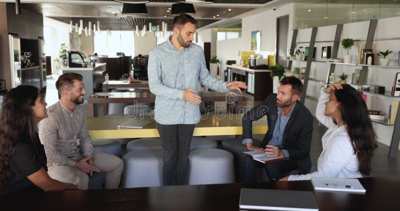 Le jeune chef hispanique dirige une séance d'information informelle avec les membres du personnel banque de vidéos