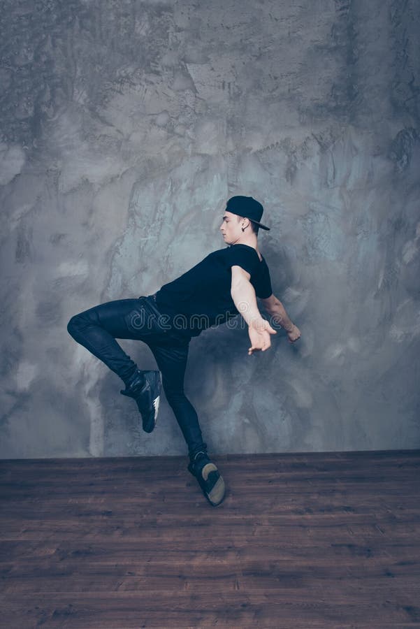 Le jeune danseur moderne pose sur un fond de studio tandis que danci photographie stock libre de droits Le jeune danseur moderne pose sur un fond de studio tandis que danci photographie stock libre de droits