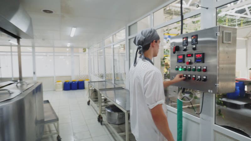 Le jeune employé appuie sur des boutons sur le panneau de commande dans l'atelier clips vidéos