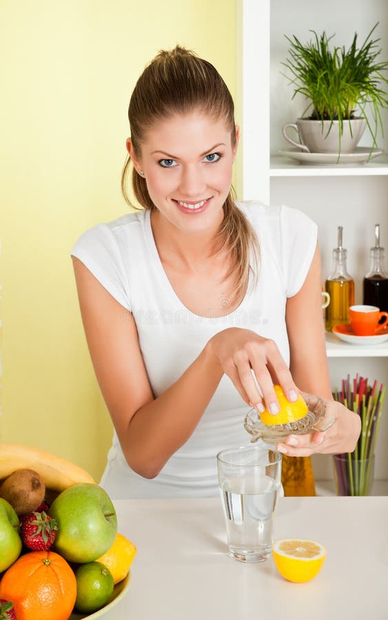Le jeune femme de beauté effectuent le jus de citron images stock Le jeune femme de beauté effectuent le jus de citron images stock