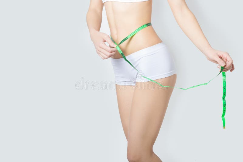 Le jeune folâtre une belle femme mince mesurant les hanches gentilles de forme parfaite, le concept d'un mode de vie sain sur un image stock