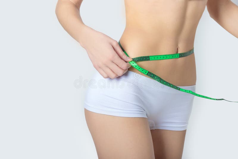 Le jeune folâtre une belle femme mince mesurant les hanches gentilles de forme parfaite, le concept d'un mode de vie sain sur un photos libres de droits
