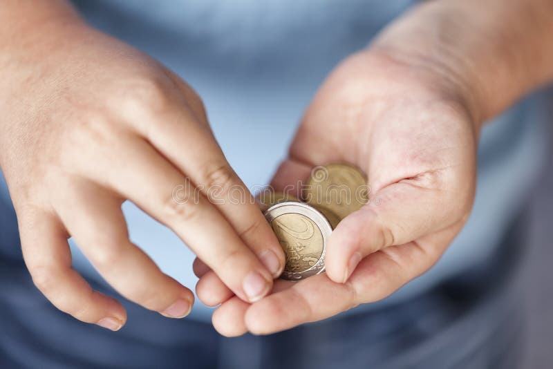Le jeune garçon tient d'euro pièces de monnaie image stock Le jeune garçon tient d'euro pièces de monnaie image stock