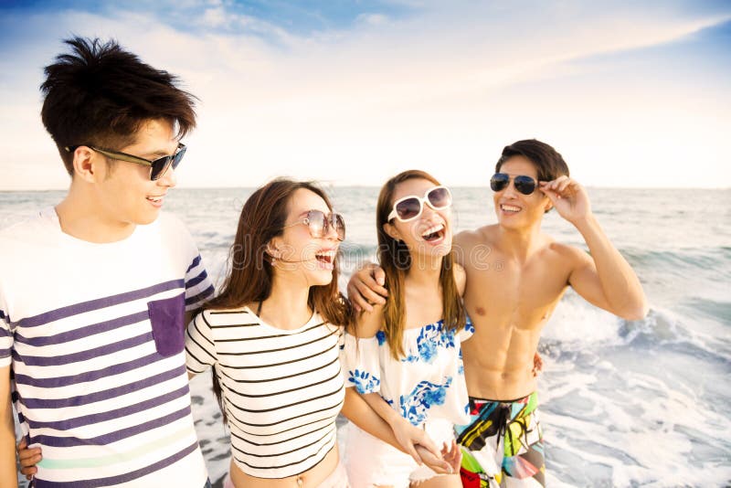 Le jeune groupe marchant sur la plage apprécient des vacances d'été images libres de droits Le jeune groupe marchant sur la plage apprécient des vacances d'été images libres de droits